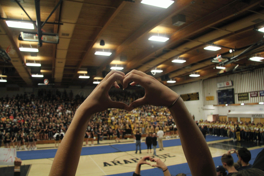 Seniors raise their hands int the shape of hearts in the stands, expressing their love of the freshman class.