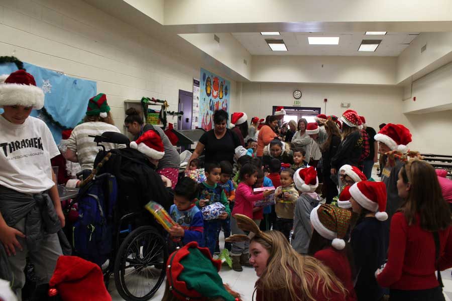 Kids at the Garden Place Academy pour into the cafeteria to receive their gifts. 