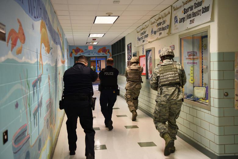 Members of the 436th Security Forces Squadron clear rooms during an active shooter exercise Feb. 26, 2018, at the George S. Welch Elementary School and Dover Air Force Base Middle School on Dover AFB, Del. Security Forces has developed a strong relationship with local and state police departments by hosting joint exercises where all units benefit. (U.S. Air Force photo by Airman 1st Class Zoe M. Wockenfuss)